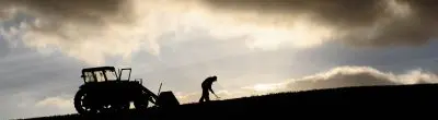 farmer in field with tractor in shadow