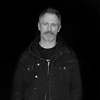 Michael Stewart Foley in front of a black background