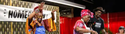 three people on-stage for a cooking demonstration