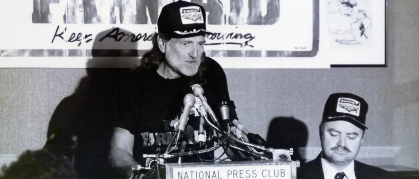 Willie Nelson speaking at a microphone