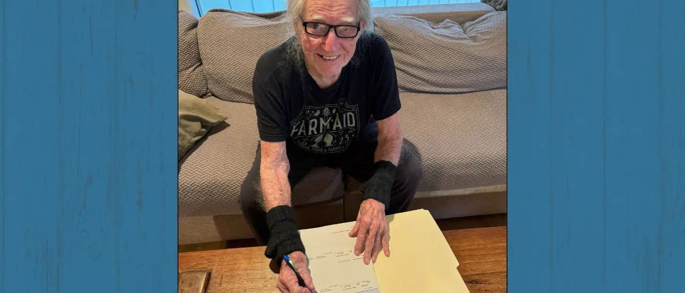 Willie Nelson signing grant checks