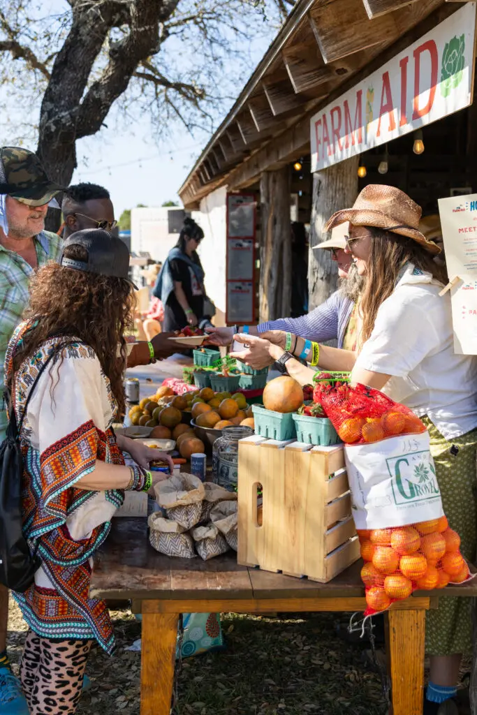 people buying fresh produce in front of a FARM AID sign
