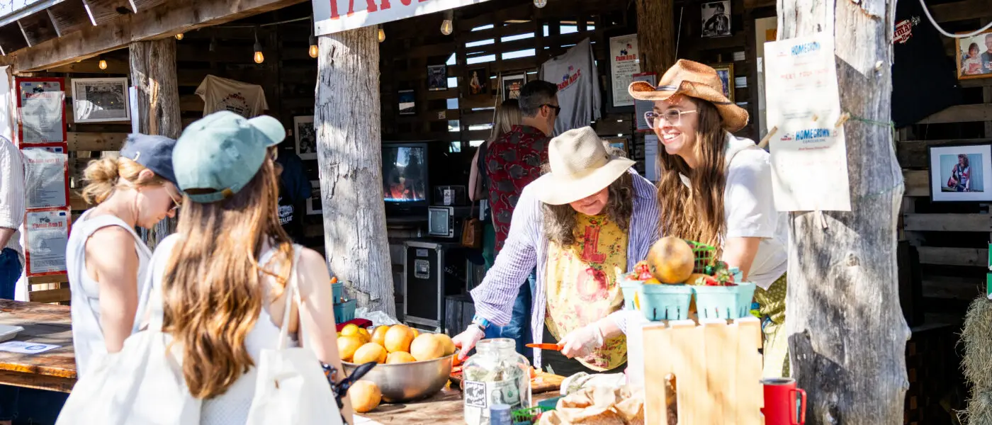 Farm Aid staff selling fresh food at the HOMEGROWN farmstand