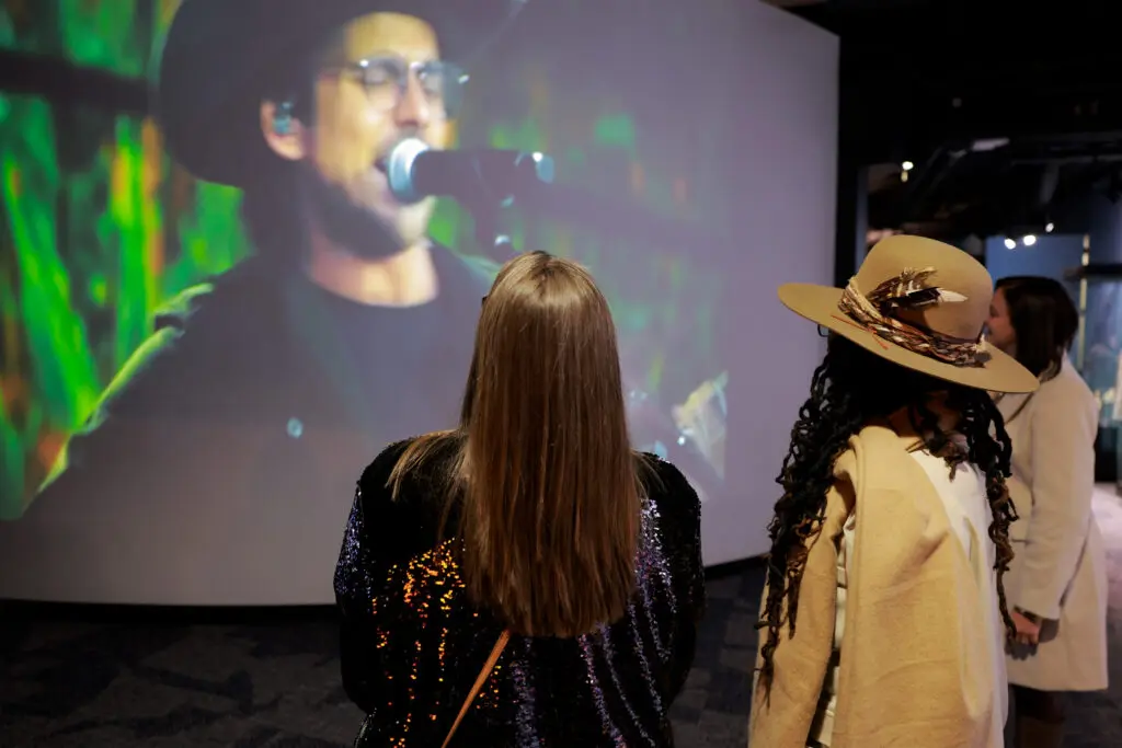 two people watching a screen with a music performance