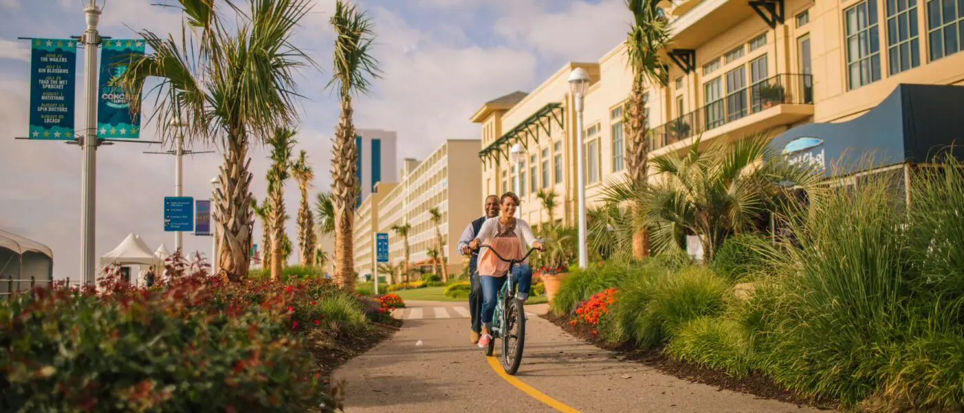 Bikers on paved trail at VA beach boardwalk.