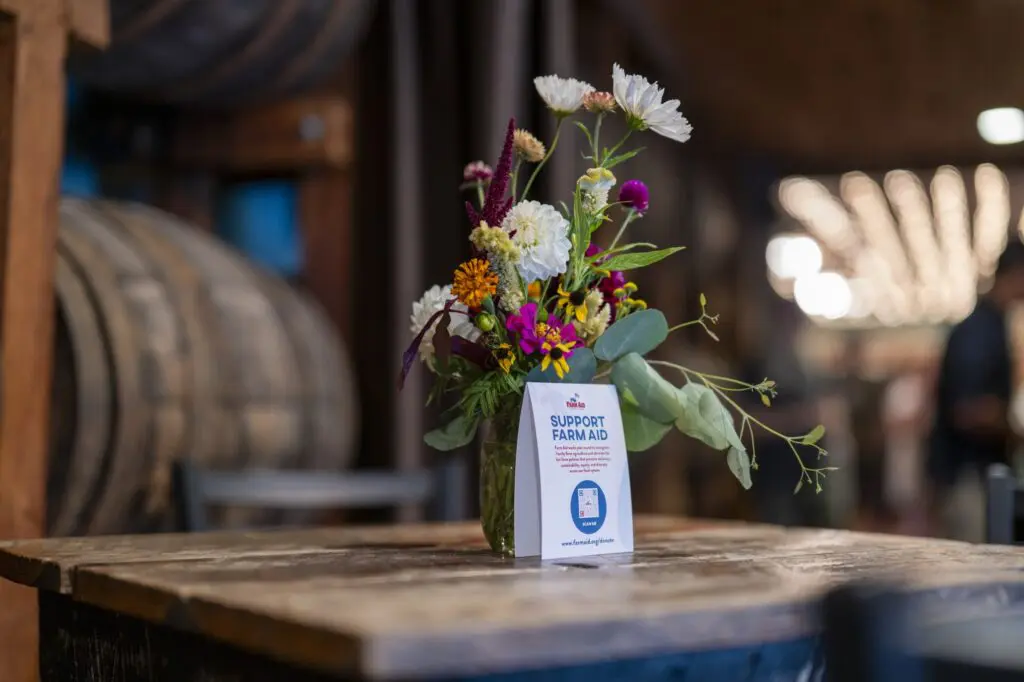 flowers with a Donate to Farm Aid paper on a table