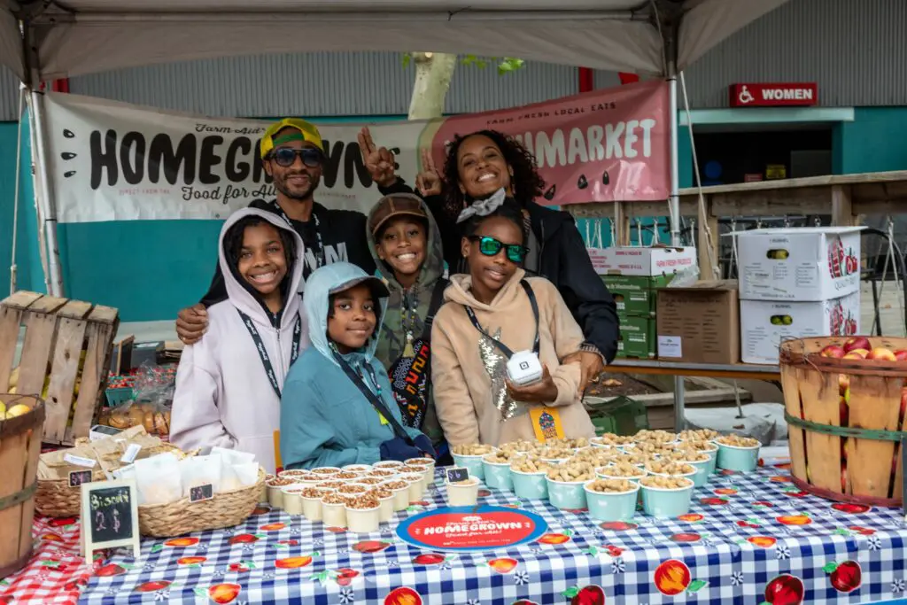 Children and young adults at the Youthmarket table selling produce