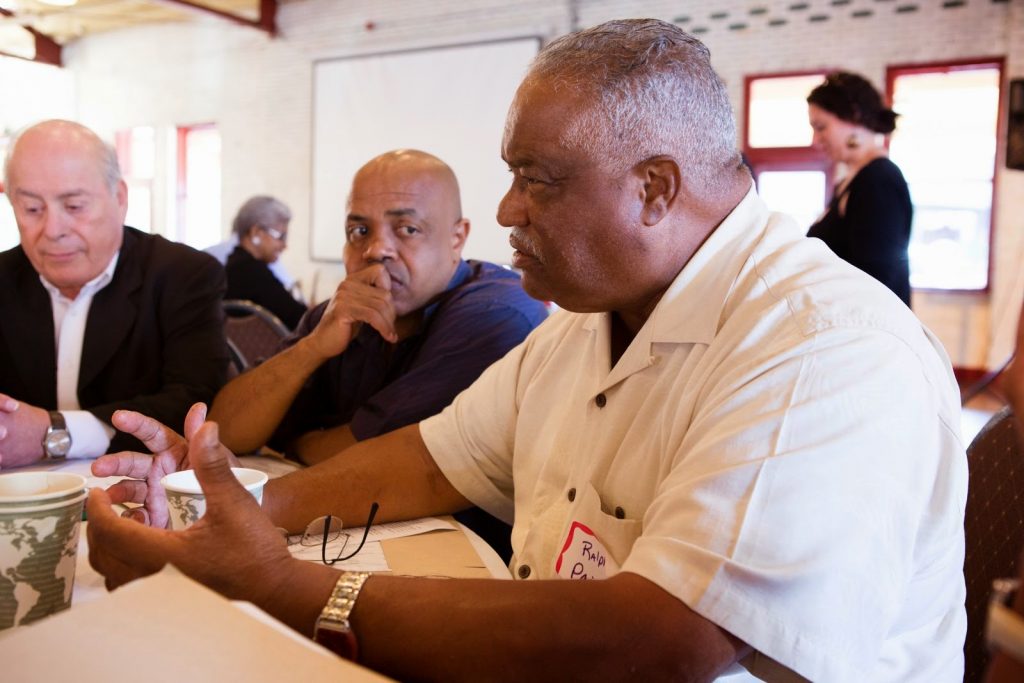 Cornelius Blanding (center) listens to Ralph Paige (foreground), with Baldemar Velasquez (left) at Farm Aid's Gathering leading up to Farm Aid 2014 in Raleigh, North Carolina.