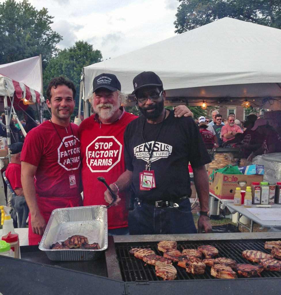 Men standing over a grill wearing "Stop Factory Farms" shirts