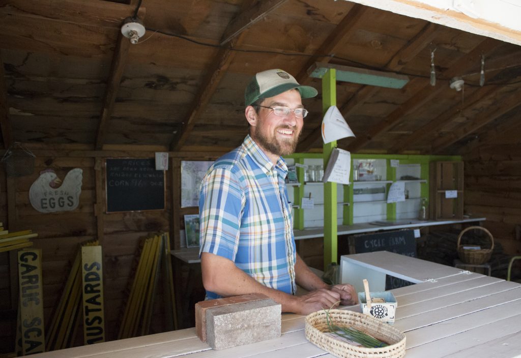 Jeremy stands in the farm stand. The farm stand was originally built in the early 1900s and used as a stand for farmers who lived there prior to Jeremy and Trish