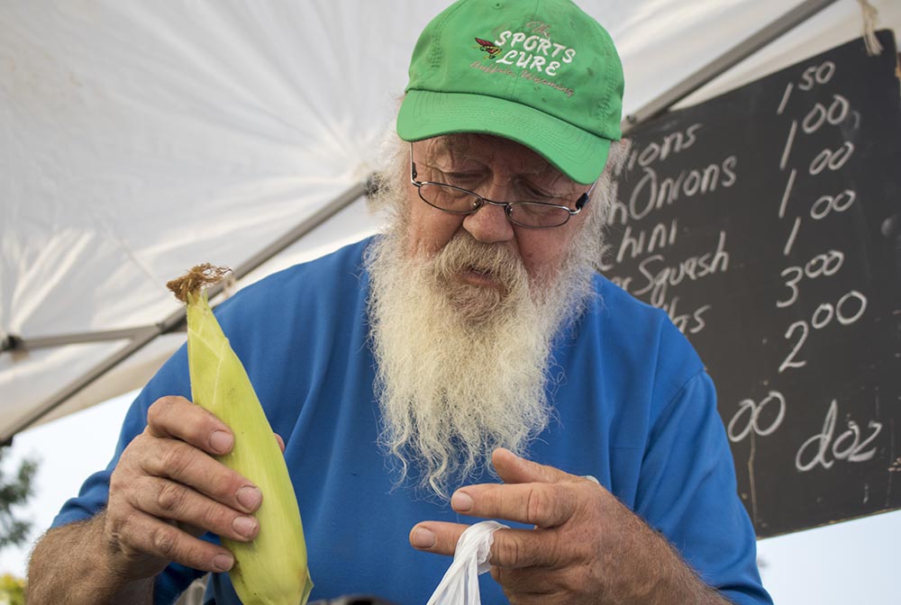 Luc bags corn for a customer at Landon’s Greenhouse Saturday Farmers Market in Sheridan, Wyoming