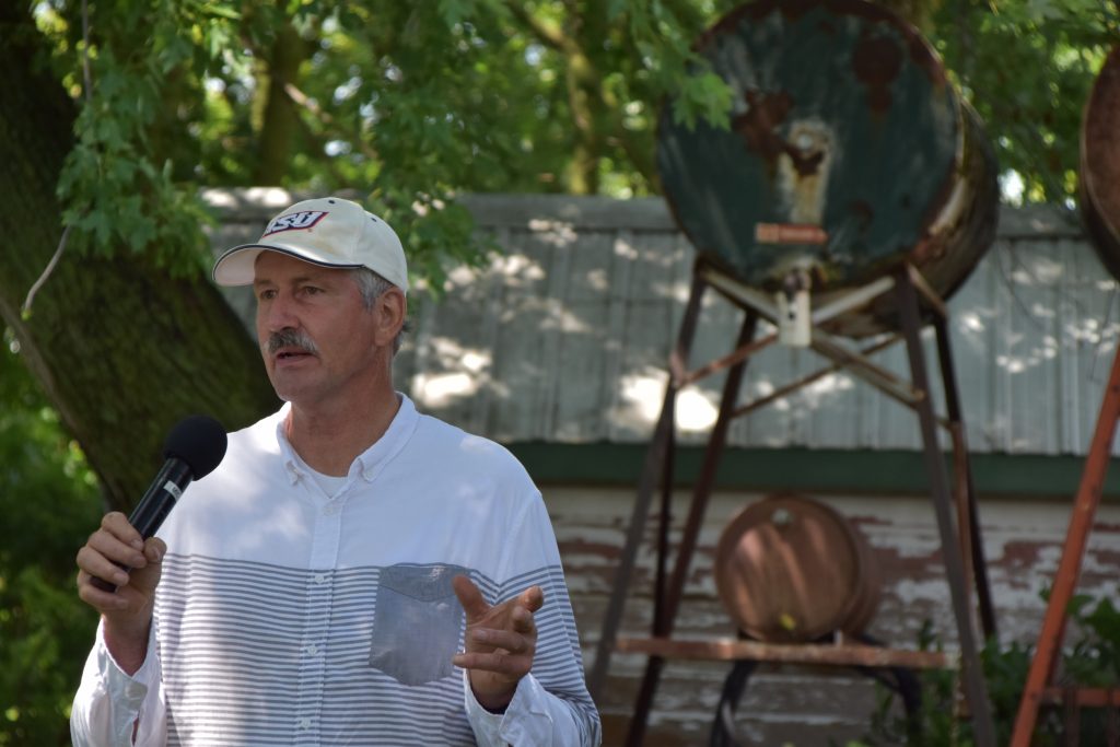 A man standing outside holding a microphone