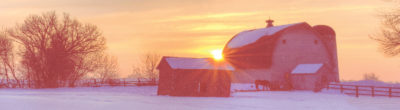 snowy barn at sunset
