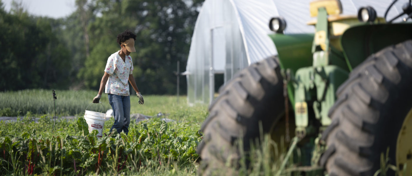 woman in farm field with tractor