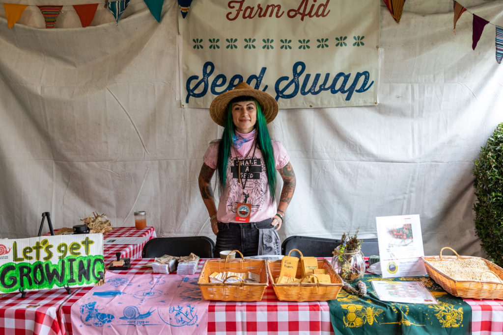 Woman standing at table for the Farm Aid 2022 Seed Swap