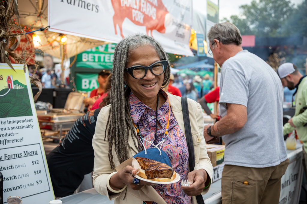 woman holding a pork chop at Farm Aid 2022