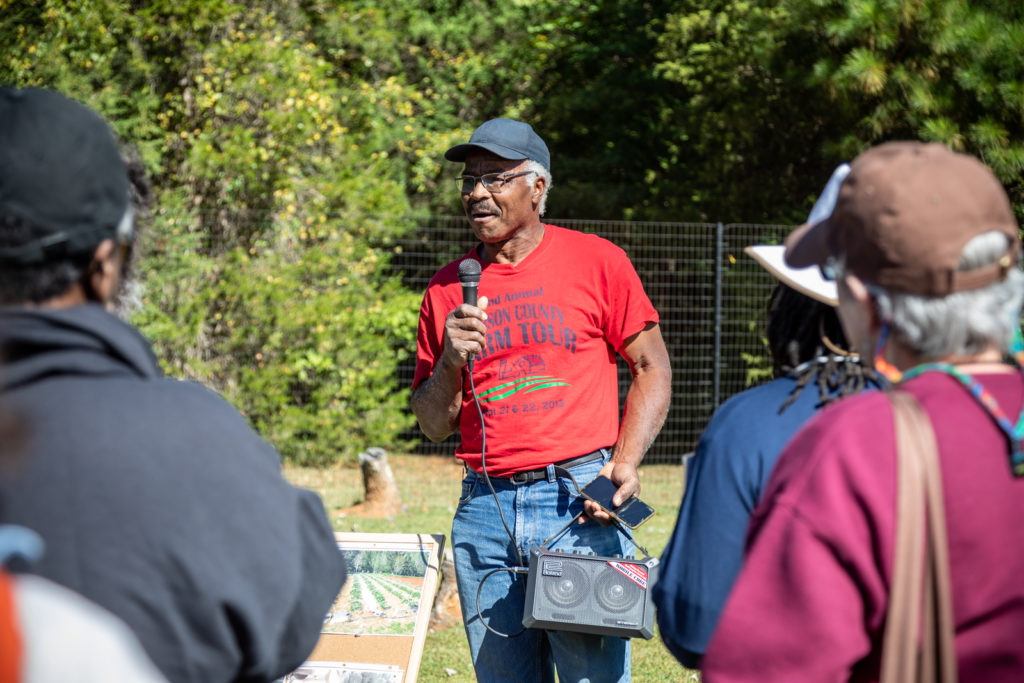 Farmer holding a microphone on a farm tour before Farm Aid 2022