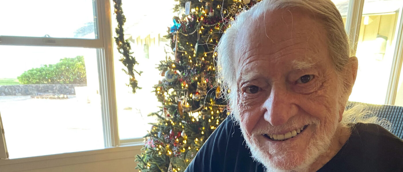 Willie Nelson signing 2023 grant checks for Farm Aid
