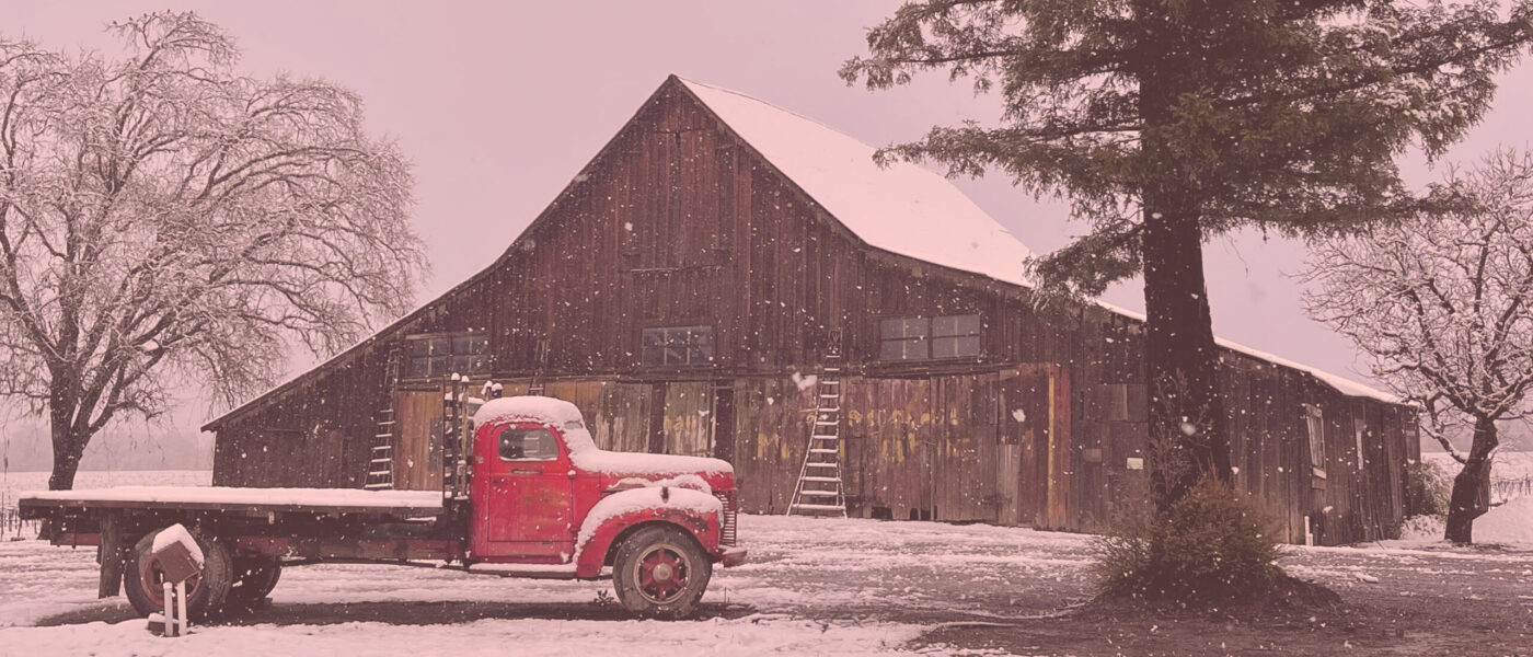 snowy barn with red truck