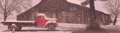 snowy barn with red truck