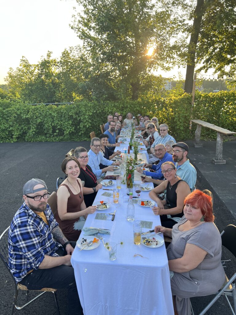 people seated at a long dinner table outdoors