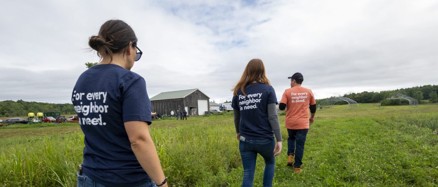 people walking through a farm field