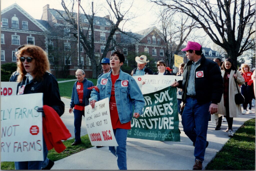 people holding anti-factory farm signs marching