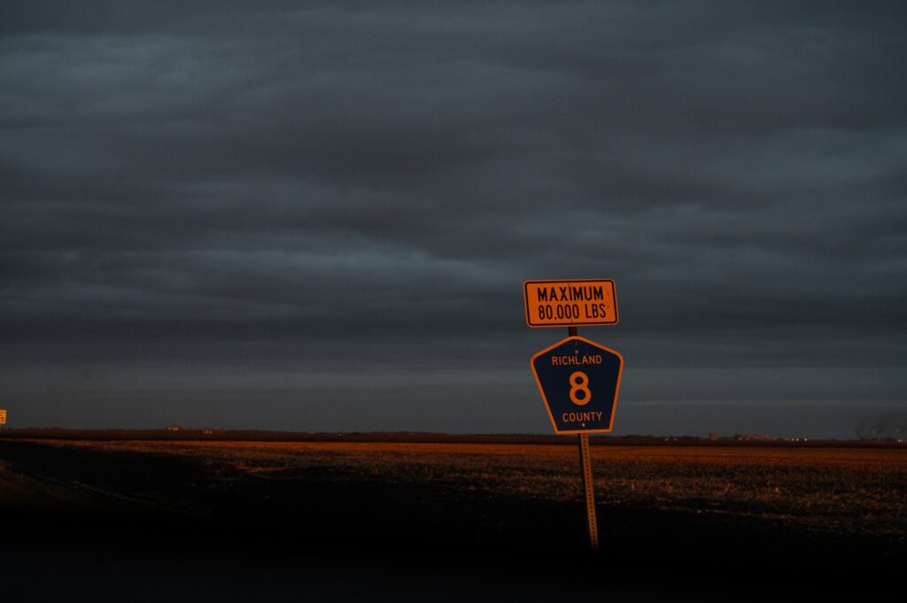 sign in front of field reading MAXIMUM 80,000 LBS | RICHLAND 8 COUNTY