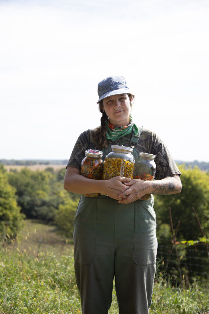 Maddy holding jars of dyed wool.