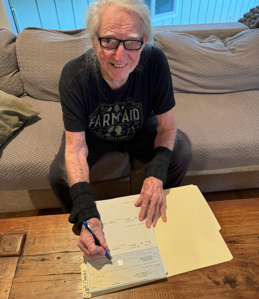 Willie Nelson signing grant checks