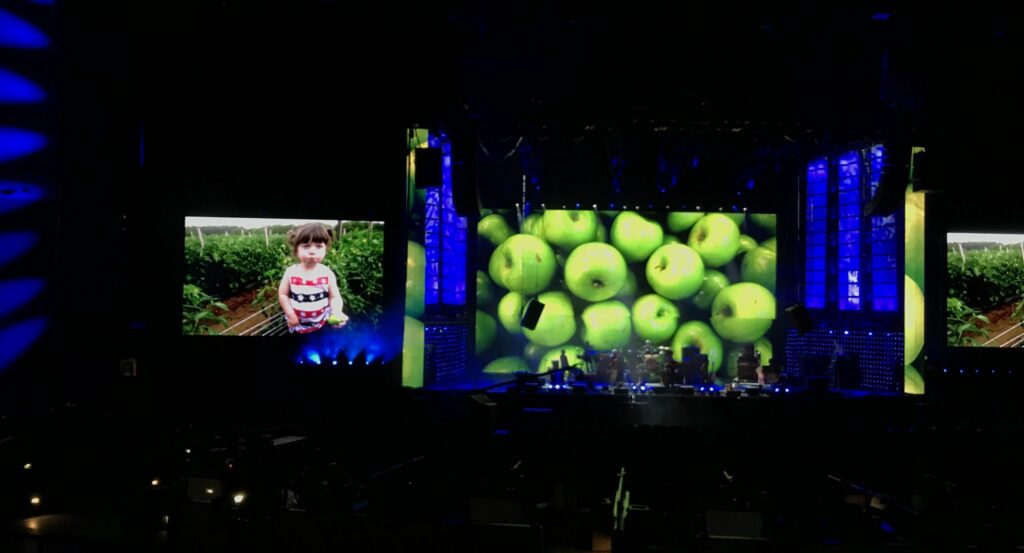 Farm photos displayed on concert screen backgrounds